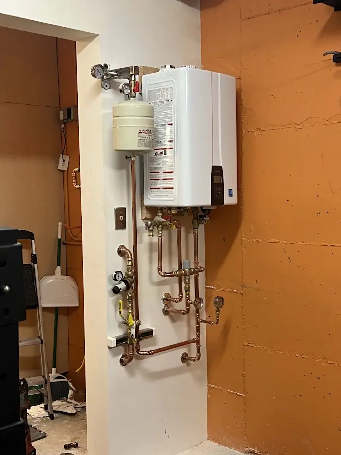 Plumbing technician inspecting water heater connections in Pebble Creek